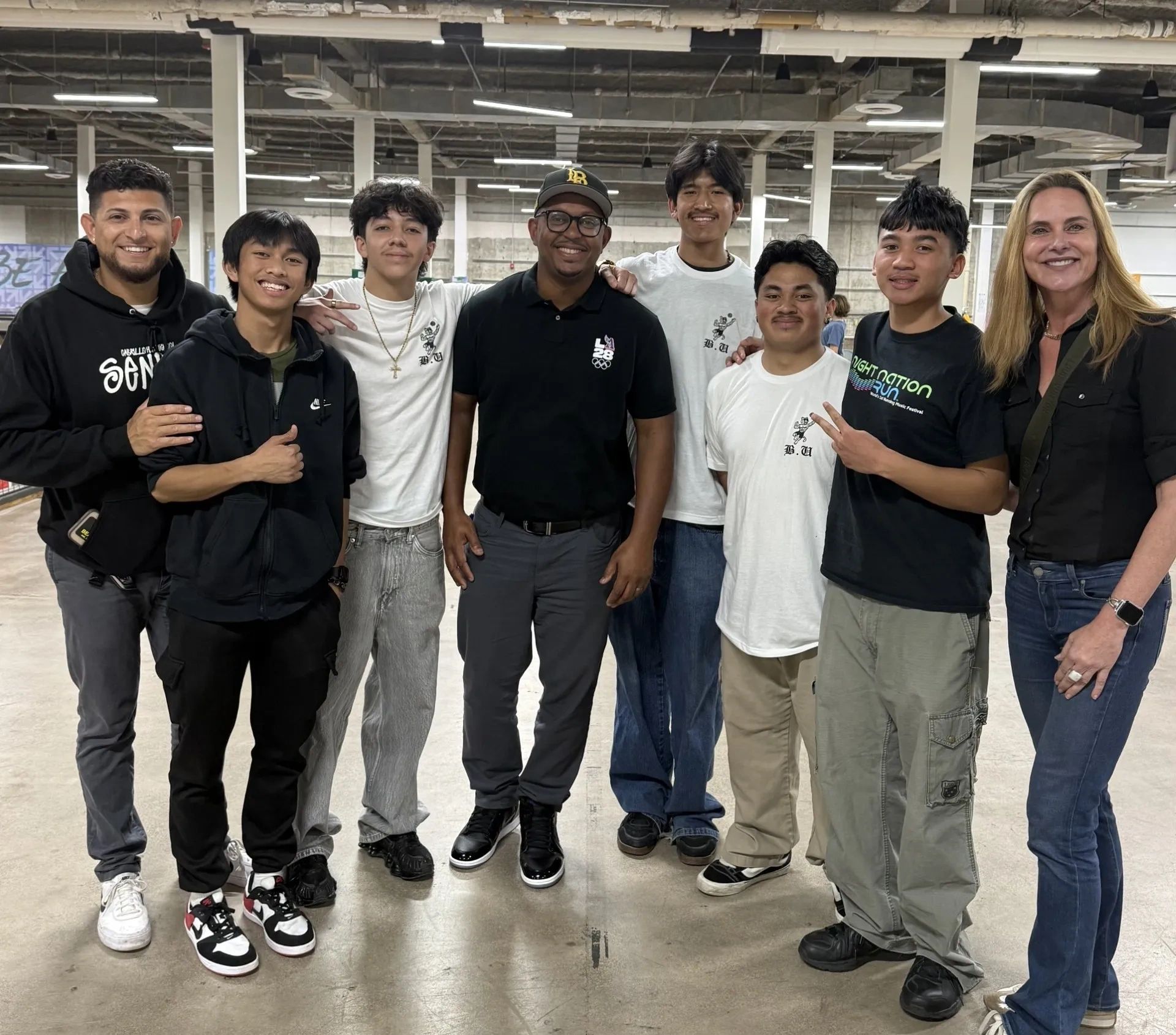 Group of eight people in an industrial warehouse setting